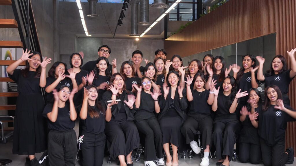 Schülerinnen und Schüler der Skills for Life Hair & Beauty School auf Bali jubeln beim Klassenfoto